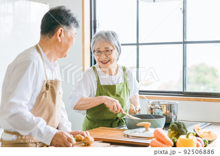 家で一緒に料理を作る笑顔の日本人老夫婦（高齢者） 92506886