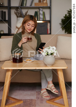 Woman Scrolling Social Media on Smartphone Woman Scrolling Social Media on Smartphone 92507984