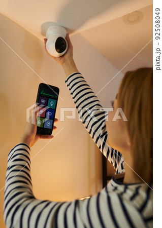 Woman Getting Access to Security Camera 92508049