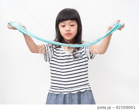 Cute girl 6 year old holding a blue slime and exited. Studio isolated on white background. Cute girl 6 year old holding a blue slime and exited. Studio isolated on white background. 92509001