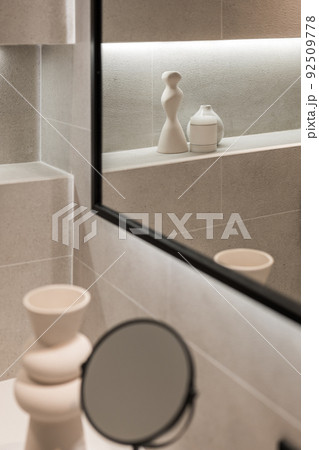 Modern bathroom interior with mirror and decorative elements in reflection. Minimalist style. Selective focus 92509778