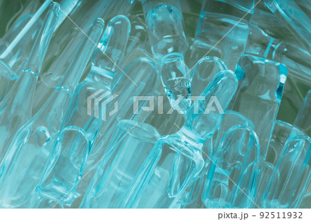Glass medical ampoule vial for injection. Medicine is liquid sodium chloride with of aqueous solution in ampulla. Close up. Bottles ampule multicolor. 92511932