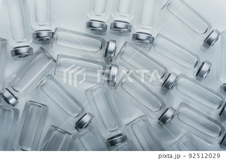 Glass medical ampoule vial for injection. Medicine is dry white drug penicillin powder or liquid with of aqueous solution in ampulla. Close up. 92512029