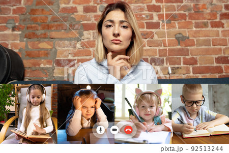 Group of different kids studying online by group video call, use video conference with each other and teacher. PC screen view with application ad. 92513244
