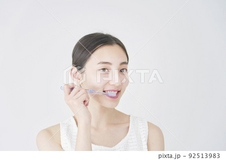 白バックで歯磨きする女性 92513983