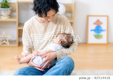 赤ちゃんを抱える若いパパ 92514416