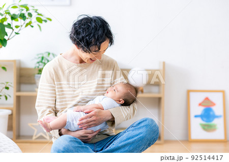 赤ちゃんを抱える若いパパ 92514417