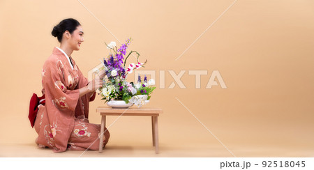 Young 20s Asian Japanese woman wear traditional Kimono, does Ikebana flower arrangement Young 20s Asian Japanese woman wear traditional Kimono, does Ikebana flower arrangement 92518045