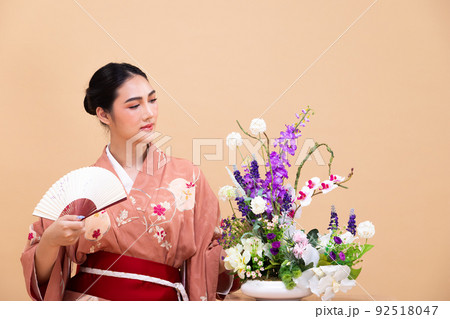 Young 20s Asian Japanese woman wear traditional Kimono, does Ikebana flower arrangement Young 20s Asian Japanese woman wear traditional Kimono, does Ikebana flower arrangement 92518047