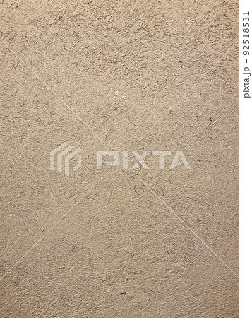 明るい茶色の土壁のなかに藁の粗い風合いが残る表面の縦長の背景画像 明るい茶色の土壁のなかに藁の粗い風合いが残る表面の縦長の背景画像 92518531