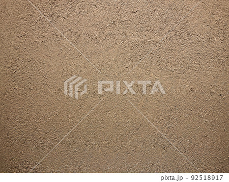 茶色の土壁のなかに藁の粗い風合いが残る表面の横長の背景画像 92518917