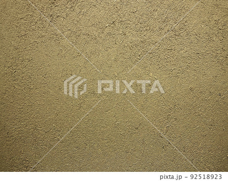 砂色の土壁のなかに藁の粗い風合いが残る表面の横長の背景画像 92518923