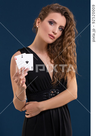 Beautiful brunette holding two aces as a sign for poker game, gambling and casino Beautiful brunette holding two aces as a sign for poker game, gambling and casino 92520009