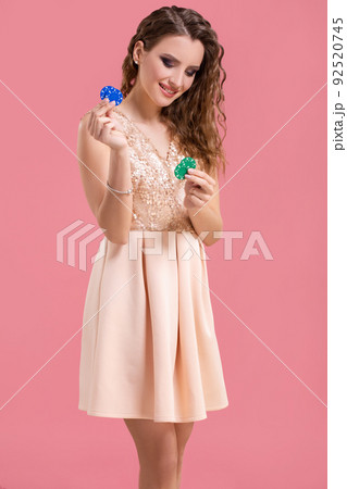 Beautiful young woman with casino chips on pink background 92520745