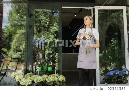 Business Woman near flower shop door. 92521585
