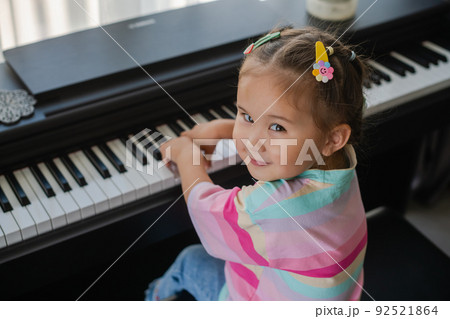 Little asian girl is happy playing the piano. Little asian girl is happy playing the piano. 92521864