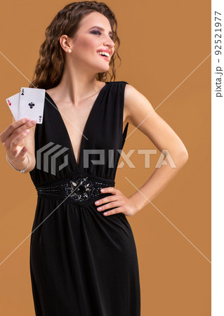 Beautiful brown-haired woman holding two aces as a sign for poker game, gambling and casino 92521977