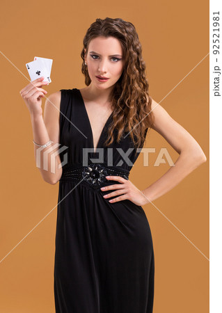 Beautiful brown-haired woman holding two aces as a sign for poker game, gambling and casino 92521981