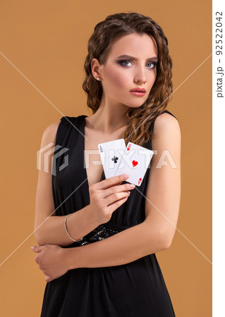 Beautiful brown-haired woman holding two aces as a sign for poker game, gambling and casino 92522042