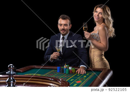 Couple gambling at roulette table in casino 92522105