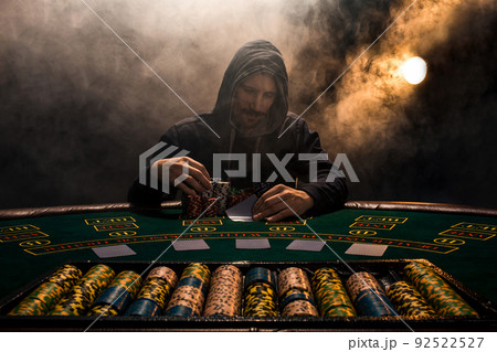 Portrait of a professional poker player sitting at pokers table 92522527