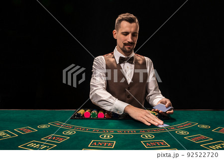 Croupier behind gambling table in a casino. Croupier behind gambling table in a casino. 92522720