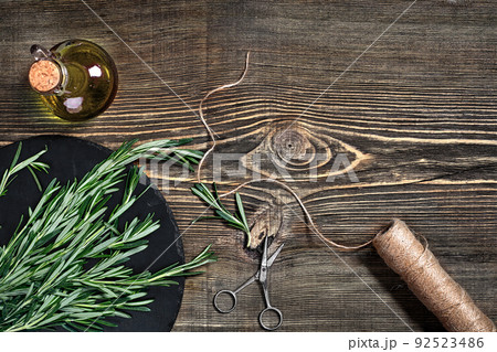 Branches of rosemary on gray wooden table. Rosemary on cutting board. Rustic style, fresh organic herbs. Branches of rosemary on gray wooden table. Rosemary on cutting board. Rustic style, fresh organic herbs. 92523486