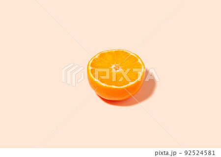 A bright slice of ripe orange on a peach background. 92524581