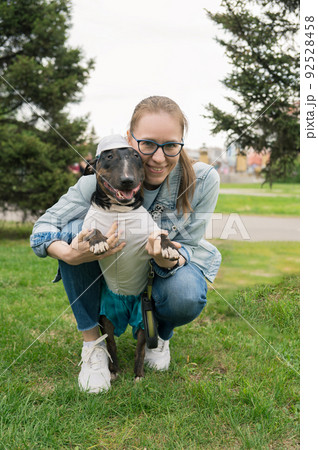 Woman walking with bull terrier outdoors 92528458