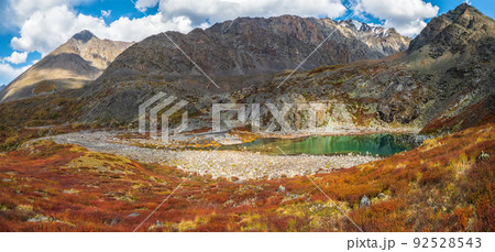 Beautiful panoramic view of the autumn misty valley. View from high mountain on picturesque landscape. Colorful nature, clear lake, stone river and yellow dried grass, environment. 92528543