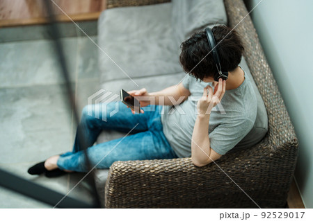 スマホで音楽を聴く若い男性 92529017