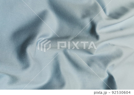 Blue crumpled or wavy fabric texture background. Abstract linen cloth soft waves. Kulirka cotton fabric. Merino yarn. Smooth elegant luxury cloth texture. Concept for banner or advertisement. 92530604