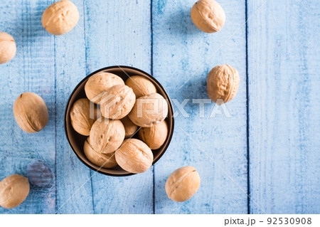 Whole ripe walnuts in shell in a bowl on the table. Organic food. Top view Whole ripe walnuts in shell in a bowl on the table. Organic food. Top view 92530908
