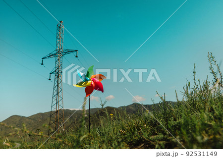 Concept of transition to alternative generation of green energy, pinwheel and power line on a natural background 92531149