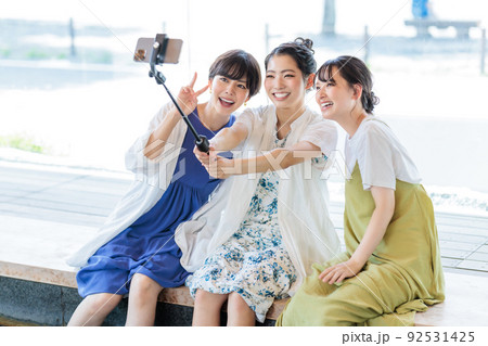 女子旅で足湯を楽しみながら写真を撮る3人の女性 女子旅で足湯を楽しみながら写真を撮る3人の女性 92531425