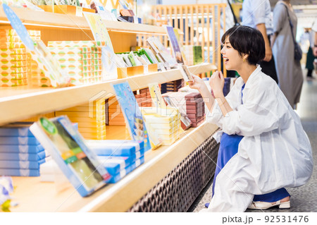 女子旅で楽しくお土産を選ぶ若い女性 92531476