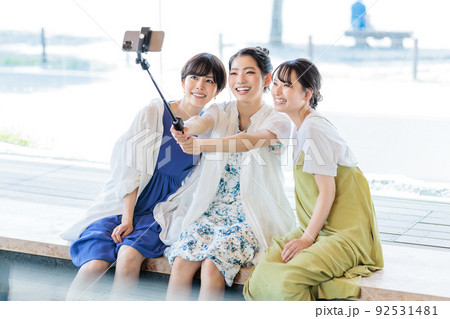 女子旅で足湯を楽しみながら写真を撮る3人の女性 女子旅で足湯を楽しみながら写真を撮る3人の女性 92531481