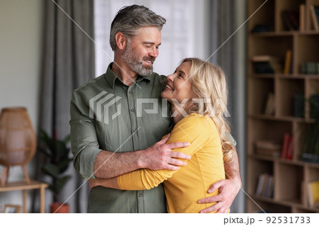 Romantic Middle Aged Couple Embracing At Home And Smiling To Each Other 92531733