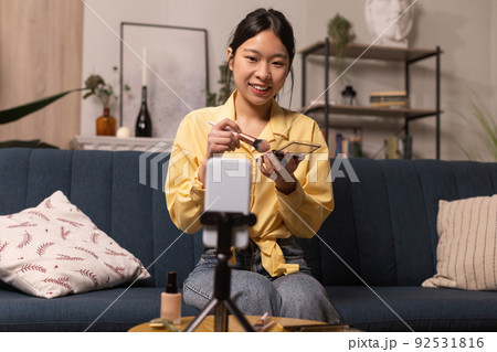 Asian Female Blogger Making Makeup Filming On Cellphone At Home 92531816
