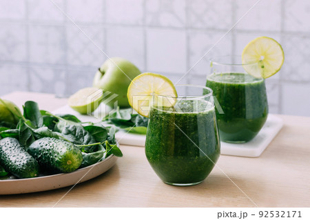 Green vegetable fruit smoothie in various glasses light background, Vegetarianism healthy lifestyle 92532171