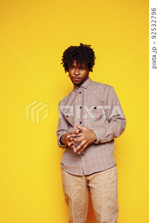 Young handsome african american guy student posing cheerful and gesturing on yellow background, lifestyle people concept close up 92532796