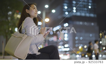 仕事終わりにスマホを見るビジネスウーマン 女性 スマートフォン 92533763