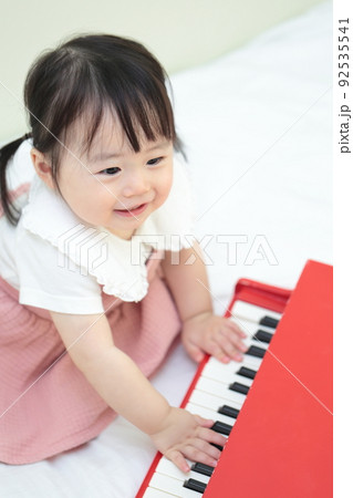 トイピアノのオモチャで遊ぶ1歳の女の子 92535541