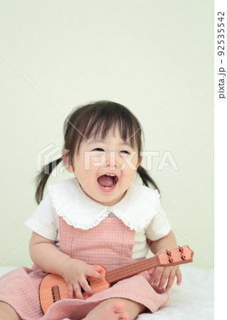 ギターのおもちゃで遊ぶ1歳の女の子 92535542