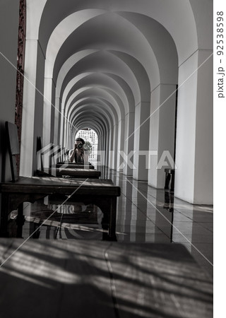 A Woman siting down on the floor and takes pictures with a camera within Loha Prasart Metal Palace at Ratchanaddaram temple. A Woman siting down on the floor and takes pictures with a camera within Loha Prasart Metal Palace at Ratchanaddaram temple. 92538598
