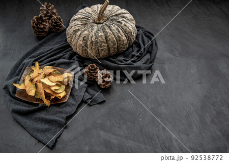Flat Lay composition with delicious of Homemade crispy pumpkin chips on Black stone texture. Flat Lay composition with delicious of Homemade crispy pumpkin chips on Black stone texture. 92538772