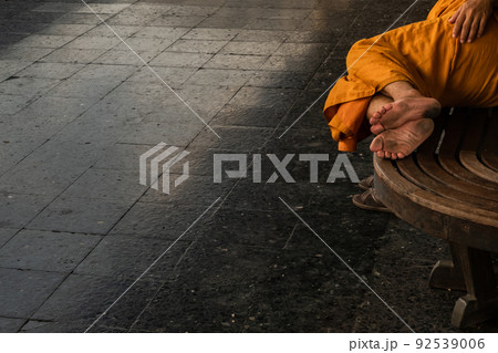 A monk is sleep on wooden chairs are waiting for trains in the area provided at Main railway station of Hua Lamphong. A monk is sleep on wooden chairs are waiting for trains in the area provided at Main railway station of Hua Lamphong. 92539006