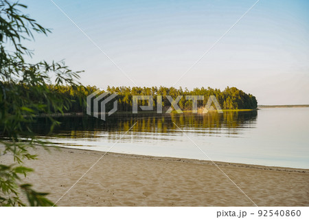 beautiful sunset at Ladoga lake. Sand beach and blue sky. Pine forest on background. Beauty of russian, Karelian nature 92540860