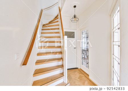 White spiral stairway connecting levels of contemporary house with wooden floor and white walls White spiral stairway connecting levels of contemporary house with wooden floor and white walls 92542833
