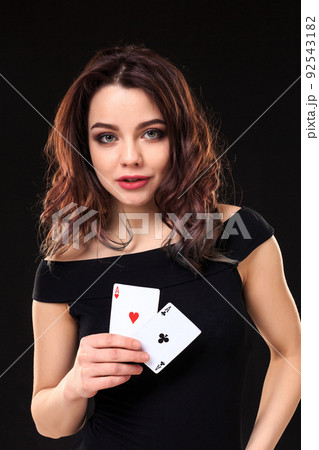 Young woman playing in the gambling on black background 92543182